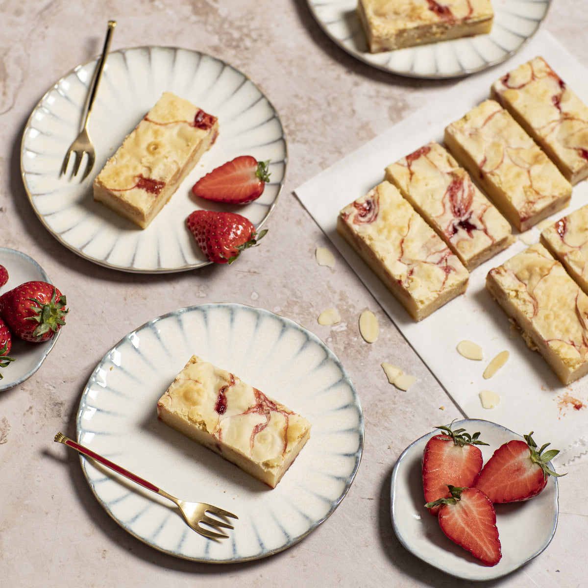Aardbeien Blondies op bordje met aardbeien amaldenen en beige ondergrond