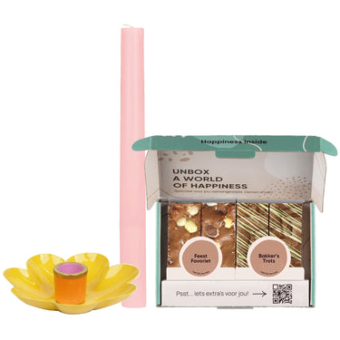 gele kaarshouder, roze kaars en paasbox op witte achtergrond