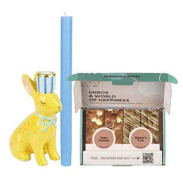 gele paashaas kaarshouder, blauwe kaars en paasbox op witte achtergrond