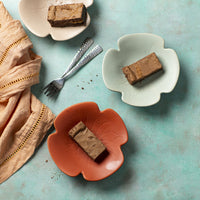 Karamel Zeezout Brownies op een bordje met een blauwe achtergrond servetten en vorkjes