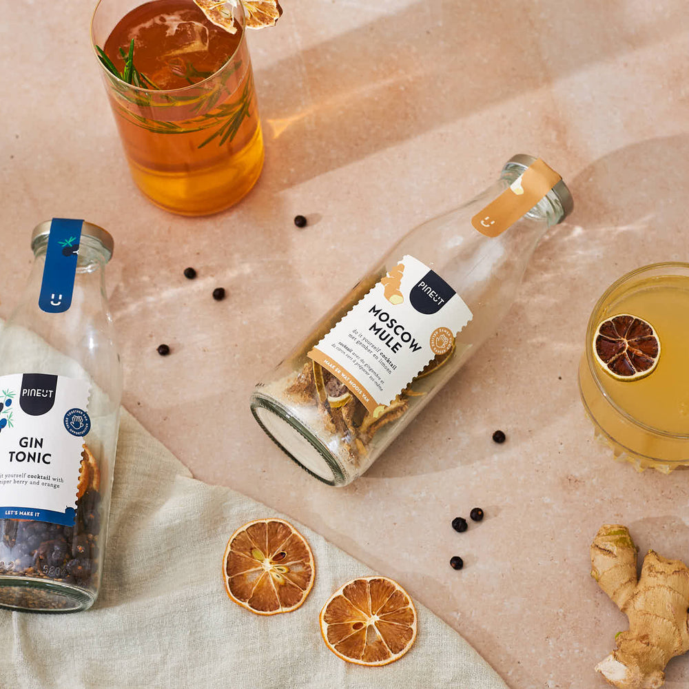 cocktails in glas en fles op zomerse achtergrond.