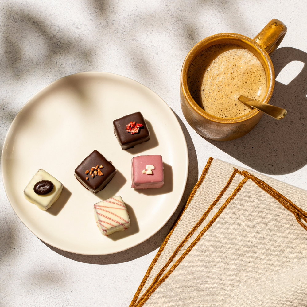 brownie bites op wit bordje met  servet, koffie op gestippelde achtergrond