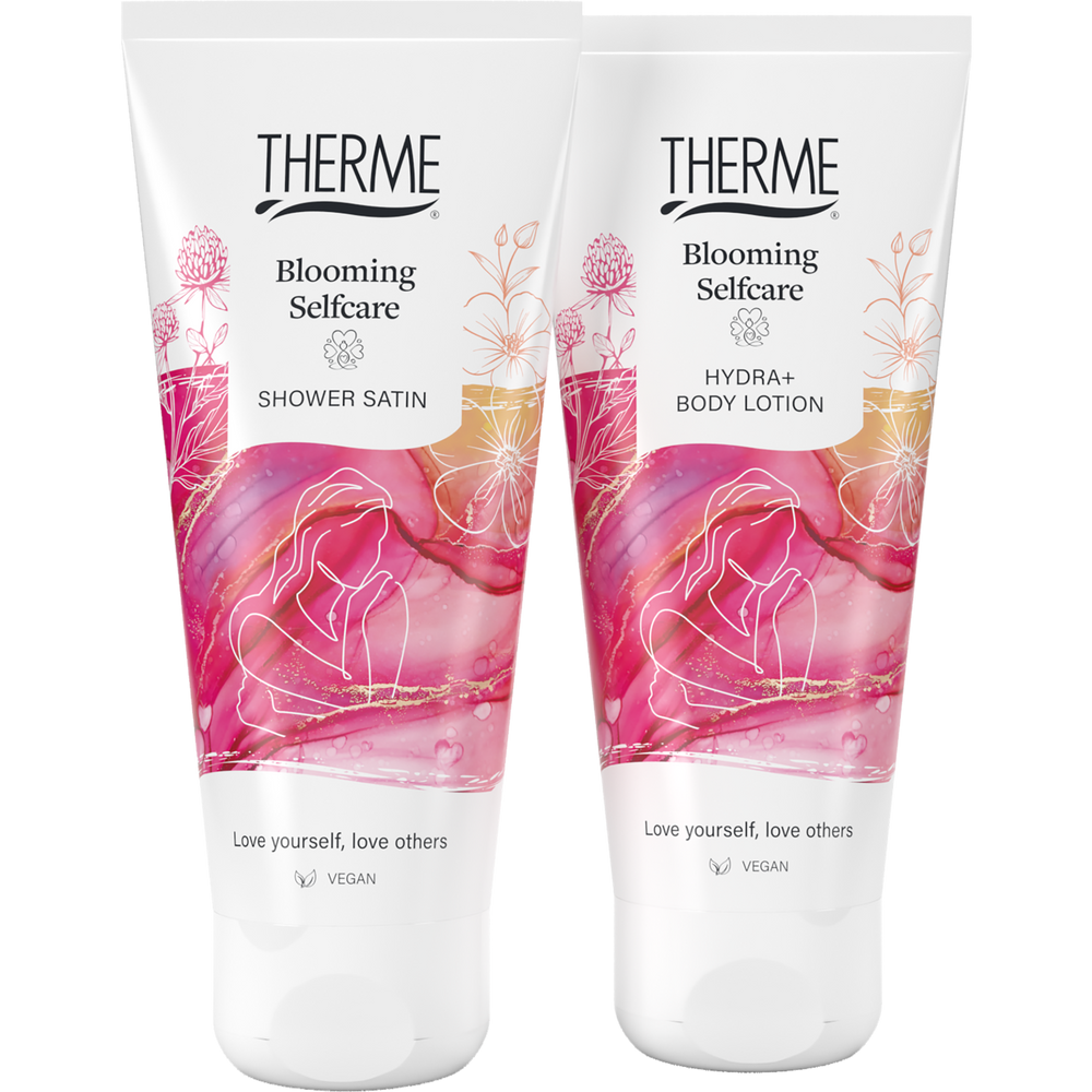 Therme Blooming Selfcare Shower Satin douchegel en Hydra+ Body Lotion in witte tubes met roze bloemendessin. Twee vegan verzorgingsproducten voor een ontspannen momentje voor jezelf.