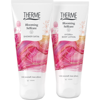 Therme Blooming Selfcare Shower Satin douchegel en Hydra+ Body Lotion in witte tubes met roze bloemendessin. Twee vegan verzorgingsproducten voor een ontspannen momentje voor jezelf.