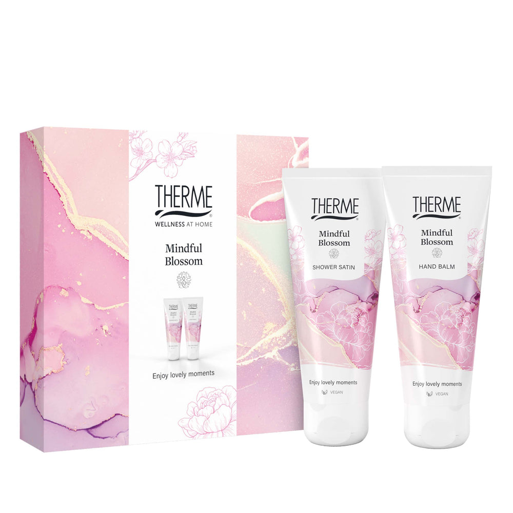 Therme Mindful Blossom geschenkset met Shower Satin douchegel en Hand Balm handcrème, naast een roze cadeauverpakking. Een fijn cadeau voor een verwenmoment voor jezelf.